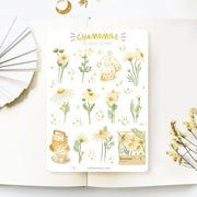 Premium Handmade Sticker Sheet Chamomile Sunflower 105mm x 148mm - a sheet on the table with a white flower branch, an opened notebook