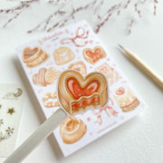 Premium Handmade Sticker Sheet 
Chocolate Lover 105mm x 148mm - a piece and a sheet on the table with a dark maroon flower branch, a pencil in the background