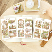 Premium Handmade Sticker Sheet Cozy Corner 105mm x 148mm - 3 sheets on the table with an opened notebook