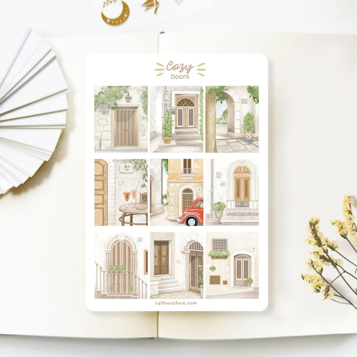 Premium Handmade Sticker Sheet Cozy Doors 105mm x 148mm - a sheet on the table with a white flower branch, an opened notebook