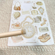 Premium Handmade Sticker Sheet Dark & Light Academia 105mm x 148mm - a piece on the stick and a sheet on the table with an opened notebook