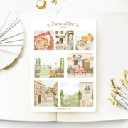 Premium Handmade Sticker Sheet Inspired by Italy 105mm x 148mm - a sheet on the table with a white flower branch, an opened notebook