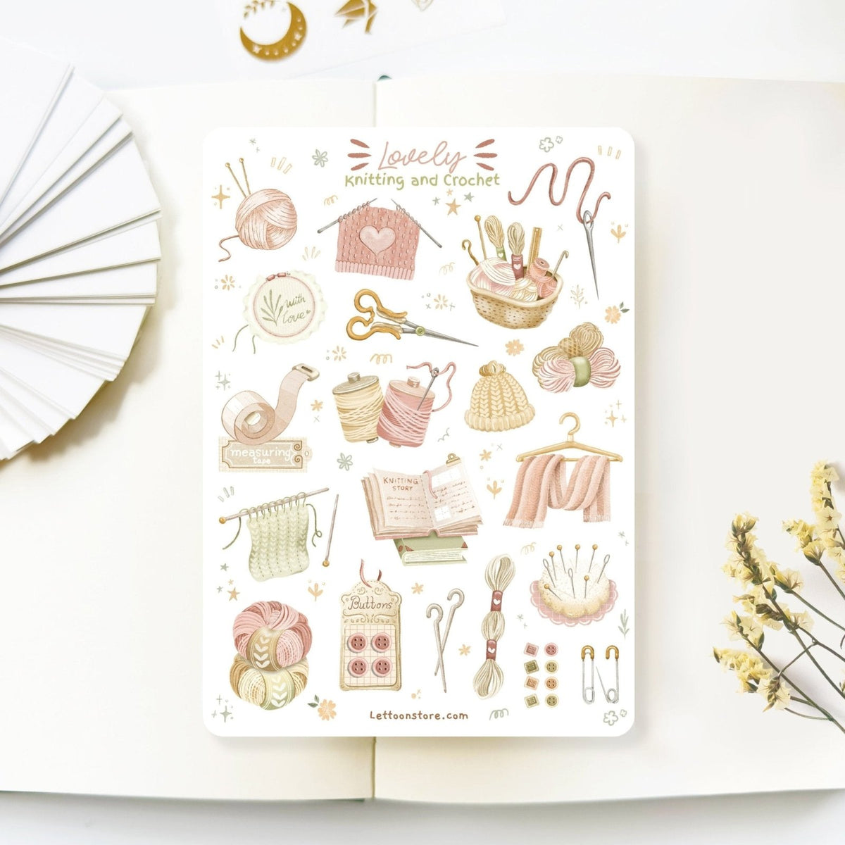 Premium Handmade Sticker Sheet Knitting Crochet 105mm x 148mm - a sheet on the table with a white flower branch, an opened notebook