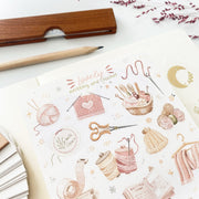 Premium Handmade Sticker Sheet Knitting Crochet 105mm x 148mm - a sheet on the table with a dark maroon flower branch, an opened notebook, a pencil, a ruler