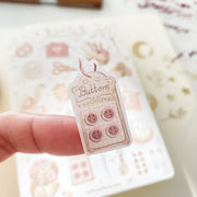 Premium Handmade Sticker Sheet Knitting Crochet 105mm x 148mm - a piece on the finger and a sheet on the table with a dark maroon flower branch, an opened notebook
