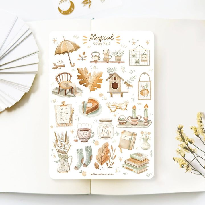 Premium Handmade Sticker Sheet Magical Cozy Fall 105mm x 148mm - a sheet on the table with a white flower branch, an opened notebook