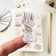 Premium Handmade Sticker Sheet Magical Cozy Fall 105mm x 148mm - a piece and a sheet on the table with a pencil, an opened notebook