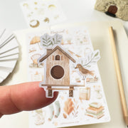 Premium Handmade Sticker Sheet Magical Cozy Fall 105mm x 148mm - a piece and a sheet on the table with a pencil, an opened notebook