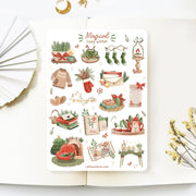 Premium Handmade Sticker Sheet Magical Cozy Winter 105mm x 148mm - a sheet on the table with a white flower branch, an opened notebook