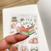 Premium Handmade Sticker Sheet Magical Cozy Winter 105mm x 148mm - a piece and a sheet on the table with an opened notebook