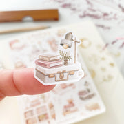 Premium Handmade Sticker Sheet Reading at Home 105mm x 148mm - a piece on the finger and a sheet on the table with a dark maroon flower branch, an opened notebook, a pencil, a ruler