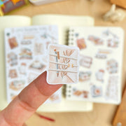 Premium Handmade Sticker Sheet Reading Time 105mm x 148mm - a piece and 2 sheets on the table with an opened notebook in the background