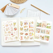 Premium Handmade Sticker Sheet The Art of Summer 105mm x 148mm - 3 sheets on the table with a pencil, an opened notebook, a chapter heading