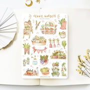 Premium Handmade Sticker Sheet 
Veggie Garden 105mm x 148mm - a sheet on the table with a white flower branch, an opened notebook
