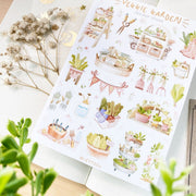 Premium Handmade Sticker Sheet 
Veggie Garden 105mm x 148mm - a sheet on the table with a white flower branch, an opened notebook, a plant branch