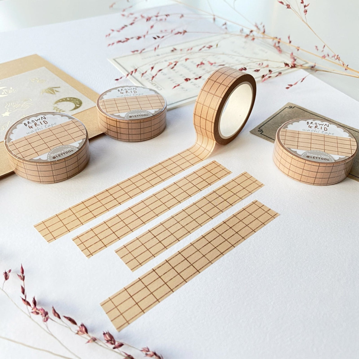 Premium Handmade Washi Tape Brown Grid 15mm x 10m - 4 pieces and 4 washi tapes on the table with 2 dark maroon flower branches, a chapter heading, a sticker sheet