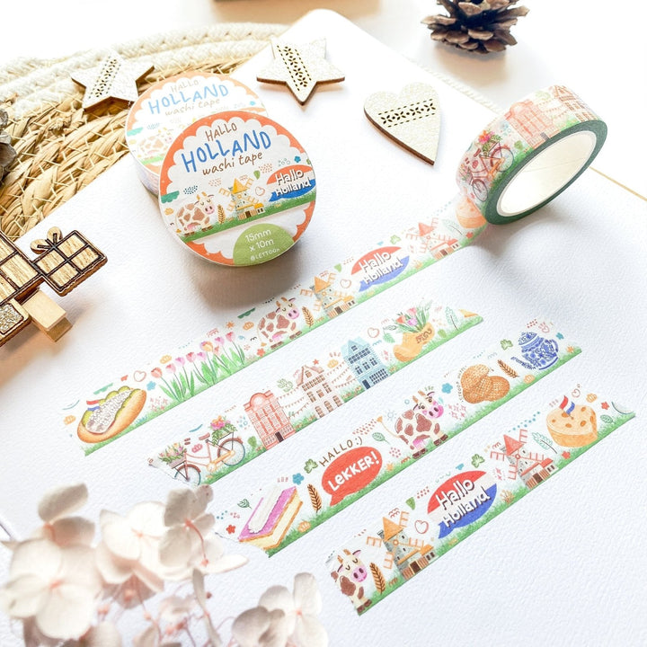 Premium Handmade Washi Tape Hallo Holland 15mm x 10m - 4 pieces and 3 washi tapes on the table with a white hydrangea flower branch, 2 wood stars, a wood heart, a wood gift, a round sedge weave, an acorn