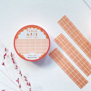 Premium Handmade Washi Tape Peach Grid 15mm x 10m - 3 pieces and a washi tape on the table with 
a dark pink flower branch