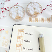 Premium Handmade Washi Tape Time Planner 15mm x 10m - a piece and 2 washi tapes on the table with 2 pink flower branches, a notebook, a pen