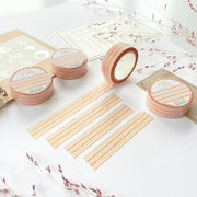Premium Handmade Washi Tape Warm Line 15mm x 10m - 4 pieces and 4 washi tapes on the table with 2 dark maroon flower branches, a sticker sheet, a chapter heading, a notebook