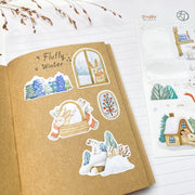 Fluffy Winter stickers in a kraft notebook: a bunny at the window, bunnies in a basket and a snowy tree