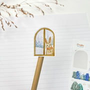 Fluffy Winter kiss-cut sticker on a pencil: a bunny looking out of a snowy window