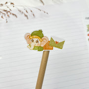 Tuk Tuk and Stroop Winter kiss-cut sticker on a pencil: Tuk Tuk in a green hat holding a letter
