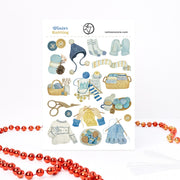 Winter Knitting sticker sheet, A6, in soft blue and mustard: a Nordic sweater, a bobble hat, mittens and baskets of yarn