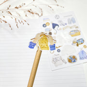 Winter Knitting kiss-cut sticker on a pencil: a yellow sweater being knitted on blue needles