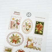 Close-up of Winter Stamps stickers on textured paper: perforated stamp edges and a gingerbread man