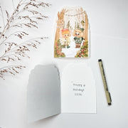 Walking in the Woods Christmas card opened, with the blank inside and a pen