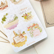 Premium Handmade Sticker Sheet A Day At Home 105mm x 148mm - a sheet on the table with an opened notebook