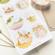Premium Handmade Sticker Sheet A Day At Home 105mm x 148mm - a sheet on the table with a white flower branch, a washi tape, an opened notebook