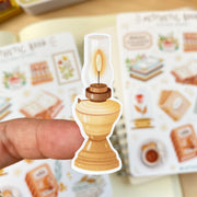 Premium Handmade Sticker Sheet Aesthetic Book 105mm x 148mm - a piece on the finger and 2 sheets on the table with an opened notebook