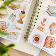 Premium Handmade Sticker Sheet Aesthetic Book 105mm x 148mm - 2 sheets on the table with a plant branch, an opened notebook