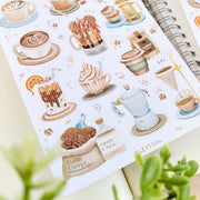 Premium Handmade Sticker Sheet Coffee 105mm x 148mm - a sheet on the table with a plant branch, an opened notebook