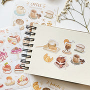 Premium Handmade Sticker Sheet Coffee 105mm x 148mm - 6 pieces on the hand note and 2 sheets on the table with a white flower branch, an opened notebook