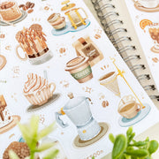 Premium Handmade Sticker Sheet Coffee 105mm x 148mm - a sheet on the table with a plant branch, an opened notebook