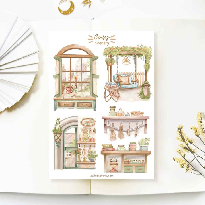 Premium Handmade Sticker Sheet Cozy Scenery 105mm x 148mm - 4 pieces on the table with a white flower branch, a opened notebook