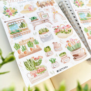 Premium Handmade Sticker Sheet Spring Garden 105mm x 148mm - 2 sheets on the table with an opened notebook, some leaves